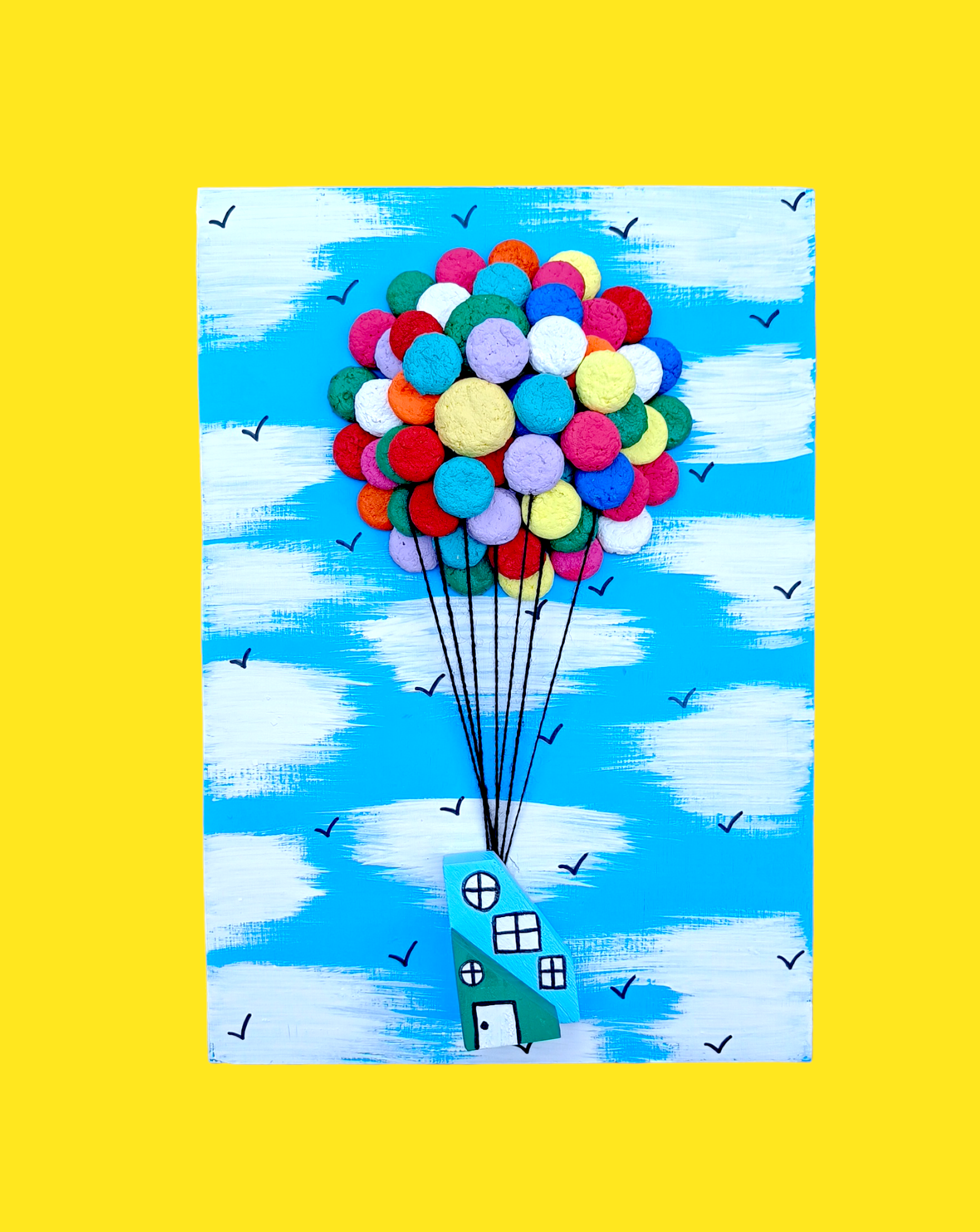 Craft Kit of Bright coloured balloons floating  house against light Blue sky with birds flying